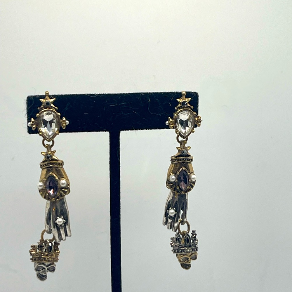 Alexander McQueen earrings crystals stones and hand holding crowned skull.